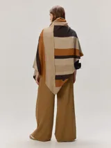 Chal envolvente con diseño de rayas horizontales en tonos beige, tostado y rosado claro, confeccionado en tejido de punto.