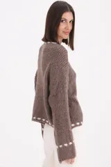 Sweater de punto grueso en color beige, con diseño de cuello redondo y detalle de pespuntes decorativos en color chocolate en el cuello, el ruedo y los puños.