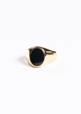 Anillo sello dorado con piedra de ónix negra de forma ovalada.