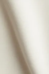 Top blanco de manga larga con escote en V, hombros caídos y cintura entallada que realza la figura. Confeccionado en tejido suave con efecto neopreno.