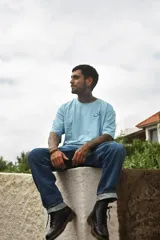 Remera blanca de algodón con cuello redondo y manga corta. Estampado pequeño en el pecho con una carita sonriente y la palabra 'Tuya'.