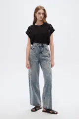 Pantalón jean de tiro alto y corte ancho, con diseño estampado de pedrería y tachas en la parte frontal.