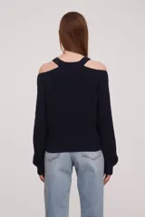 Sweater rojo de tejido de punto con cuello redondo y manga larga con hombros descubiertos.