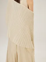 Chal de punto color beige con textura acanalada y sutil brillo metalizado.