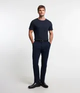 Pantalón de vestir para hombre, color beige claro, de corte slim y sastrería. Presenta cierre frontal con botón y cremallera, y bolsillos laterales y traseros.