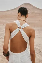 Vestido midi blanco con bordados florales perforados, escote en V, sin mangas y tirantes cruzados en la espalda.