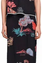 Falda midi de corte recto con cintura elástica y estampado de paisajes marinos en tonos coloridos sobre base negra.