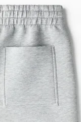 Pantalón tipo jogger de corte relajado con efecto neopreno, cintura elástica con cordón ajustable, bolsillos laterales al bies y bolsillo trasero de parche.