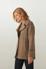 Chaquetón color beige con cuello, abrochadura simple con botón en el cuello, bolsillos ojal y detalle de martingala en mangas. Prenda con forro al tono.