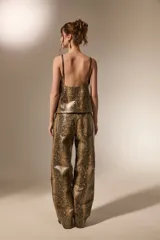 Pantalon de corte recto con diseño de estampado de piel de serpiente, confeccionado en cuero sintético (PU). Presenta bolsillos laterales y cierre frontal con botón.