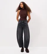 Pantalón de jean color azul oscuro, modelo baggy balloon de tiro medio, con bolsillos funcionales, trabillas en la cintura y recortes laterales que aportan una silueta redondeada.