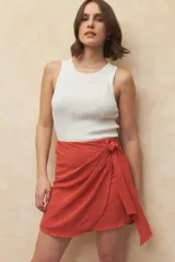 Minifalda negra con diseño cruzado y lazo lateral.