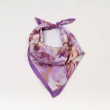 Pañuelo cuadrado de seda con estampado floral en tonos lila, violeta y beige, con borde liso en color violeta.