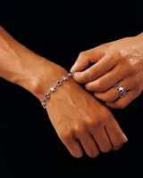 Pulsera plateada con eslabones y dijes de estrellas esmaltadas en color azul.