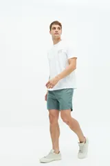 Short de baño liso con cintura elástica y cordón ajustable. Cuenta con dos bolsillos laterales, un bolsillo trasero y logo bordado en el ruedo. Confeccionado en tejido ligero de secado rápido.