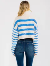 Sweater crop de cuello tortuga, color blanco con rayas azules y aplicación de lentejuelas, manga larga y tejido extra suave de media estación.