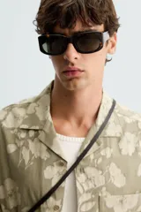 Camisa de manga corta y corte relajado confeccionada en tejido de algodón con diseño jacquard floral. Presenta cuello bowling, un bolsillo de plastrón en el pecho y cierre frontal con botones.