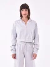 Campera tipo hoodie cropped con cierre frontal, capucha y mangas largas con puños acanalados.