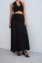 Falda larga negra de corte recto con frunce lateral en la cintura.