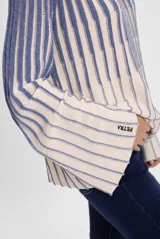 Sweater de punto con diseño a rayas verticales en color beige y azul. Presenta mangas acampanadas y el logo de la marca bordado en el puño.