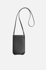 Bolso bandolera negro de cuero con bolsillo plano frontal y correa larga del mismo material.