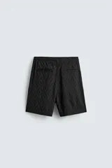 Bermuda de corte regular confeccionada en tejido fluido con textura jacquard geométrica. Presenta cintura elástica con cordón ajustable, bolsillos laterales y bolsillos traseros de vivo.
