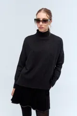 Polera tejida de punto confeccionada en lambswool color gris claro, con cuello alto y calce holgado.