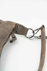 Bolso de mano de eco cuero en tono marrón topo con efecto desgastado. Posee cierre superior principal, múltiples bolsillos externos con cremallera y herrajes metálicos plateados oscuros.