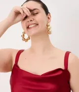 Musculosa de satén color negro con escote degagê drapeado, breteles finos ajustables y bajo asimétrico.