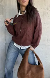 Sweater de tejido de punto color chocolate, con diseño de flores bordadas en relieve, cuello redondo y mangas largas con puños elásticos.
