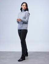 Polera de tejido fino, color rosado, con cuello alto, manga larga y detalle de tajo en los puños.