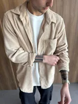 Sobrecamisa de pana color beige, con cuello clásico, cierre frontal de botones y un bolsillo en el pecho.