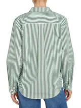 Camisa de corte amplio, a rayas verticales verdes y blancas, con cuello inglés, cierre frontal con botones y logo de Tommy Hilfiger bordado en el puño.
