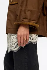 Anillo de latón con acabado dorado y diseño en espiral de tres vueltas. Presenta una textura orgánica y fluida con extremos redondeados, ofreciendo un estilo distintivo y elegante.