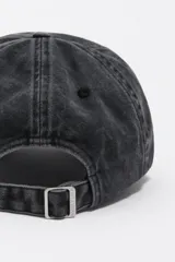 Gorra de algodón con efecto lavado, diseño clásico de seis paneles con visera curva. Presenta un bordado frontal con motivos de animales y texto en color rojo.