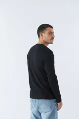 Remera de manga larga negra con estampado rectangular en el frente con letras grises. Corte recto y cuello redondo.
