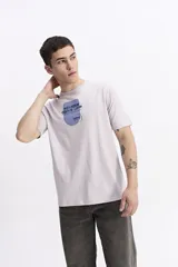 Remera de manga corta color lila, con escote redondo y ajuste regular. Presenta un estampado frontal con la frase "NEVER GIVE UP" en azul y el logo de la marca "mistral".