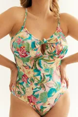 Malla entera con estampado floral y de palmeras en tonos rosa, verde, amarillo y celeste. Tiene breteles finos, escote con moño y espalda cruzada.