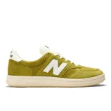 Championes New Balance modelo 500, color verde mostaza, con logo 'N' blanco en el lateral. Presentan una estructura de ante y nobuk con detalles perforados en la puntera y una entresuela de goma de color crema.