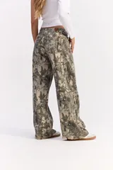 Jean de corte recto y tiro medio con estampado camuflado de estilo forestal. Presenta cierre frontal con botón y bolsillos laterales y traseros.