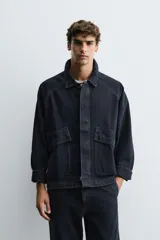 Cazadora de denim de algodón con efecto lavado, cuello solapa, manga larga y cierre frontal con cremallera oculta por solapa con botones a presión. Presenta bolsillos de plastrón con solapa en el delantero.