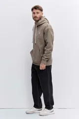 Buzo con capucha tipo canguro confeccionado en tela de corduroy color marrón. Presenta cordones blancos en contraste, bolsillo frontal tipo canguro y logo bordado sutil en el pecho.