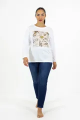 Remera de manga larga color blanco, con cuello redondo y corte recto. Presenta un estampado frontal rectangular dividido en cuadrículas con motivos florales y un corazón central en tonos dorados.