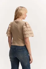 Remera color tostado con cuerpo acanalado y mangas cortas abullonadas con bordados calados.