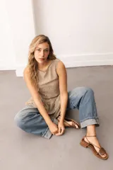 Vestido corto sin mangas de encaje negro, con escote bote y terminación de volados superpuestos.