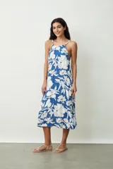 Vestido midi de corte holgado con estampado floral en tonos azul y blanco, presenta escote halter con breteles finos y diseño sin mangas.