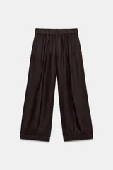 Pantalón de tiro medio confeccionado en lino, con cintura elástica y diseño de pierna ancha tipo barrel. Cuenta con bolsillos laterales.