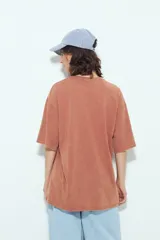 Remerón de manga corta color terracota con efecto gastado, silueta amplia y bolsillo aplicado con bordado de perro salchicha.