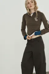 Pantalón cargo de tiro alto con corte holgado y diseño de volumen. Presenta bolsillos laterales tipo cargo, bolsillos frontales clásicos y cierre frontal con cremallera y botón.