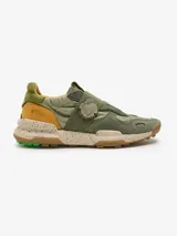 Zapatillas Satorisan modelo Chacrona Lin.Ela., color verde militar con detalles en mostaza y suela speckle con tacos de goma verde. Presentan cierre de velcro con aplique en forma de corazón y diseño de estilo técnico.